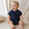 Gentle Nest model hero — Solid Polo Romper, Dark Blue, worn by Eli (GN-B02)