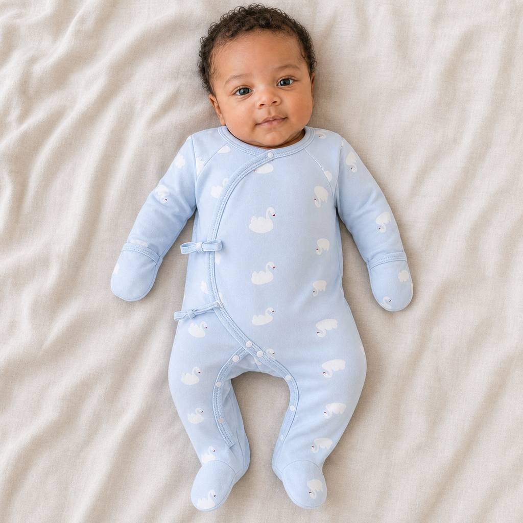Gentle Nest model hero — Newborn Wrap Footie Pajama, Blue Swan, worn by Amari (GN-N01)