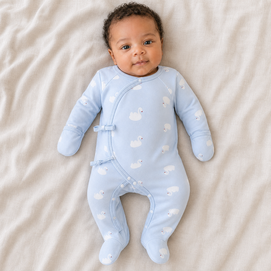 Gentle Nest model hero — Newborn Wrap Footie Pajama, Blue Swan, worn by Amari (GN-N01)