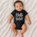 Gentle Nest model hero — Hello Daddy Baby Announcement Romper, Black, worn by Amari (GN-N01)