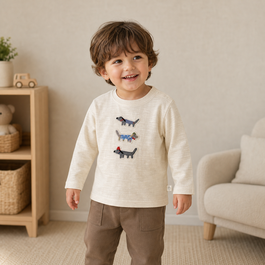 Toddler wearing the beige embroidered dog cotton top