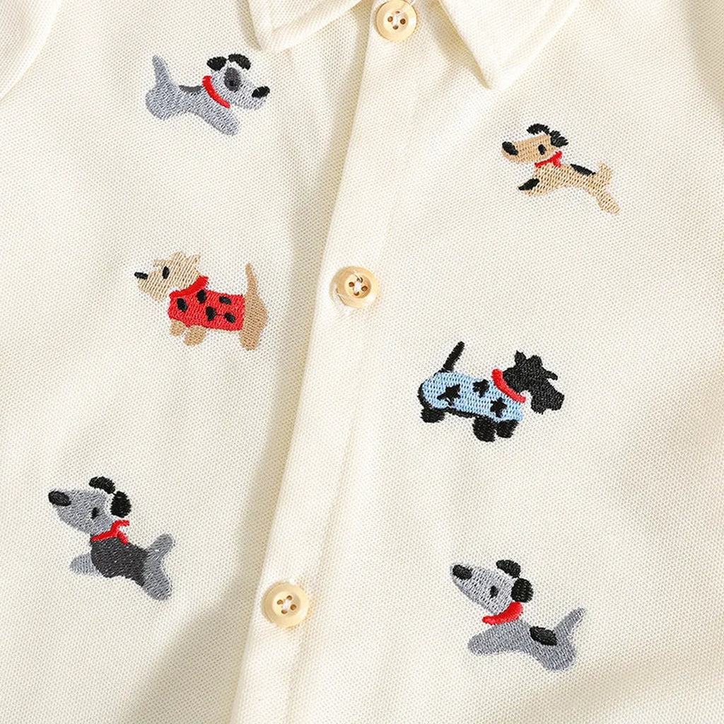 Close view of embroidered dog details on beige romper