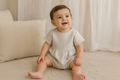 Baby wearing Traditional Cotton Baby Romper in Beige