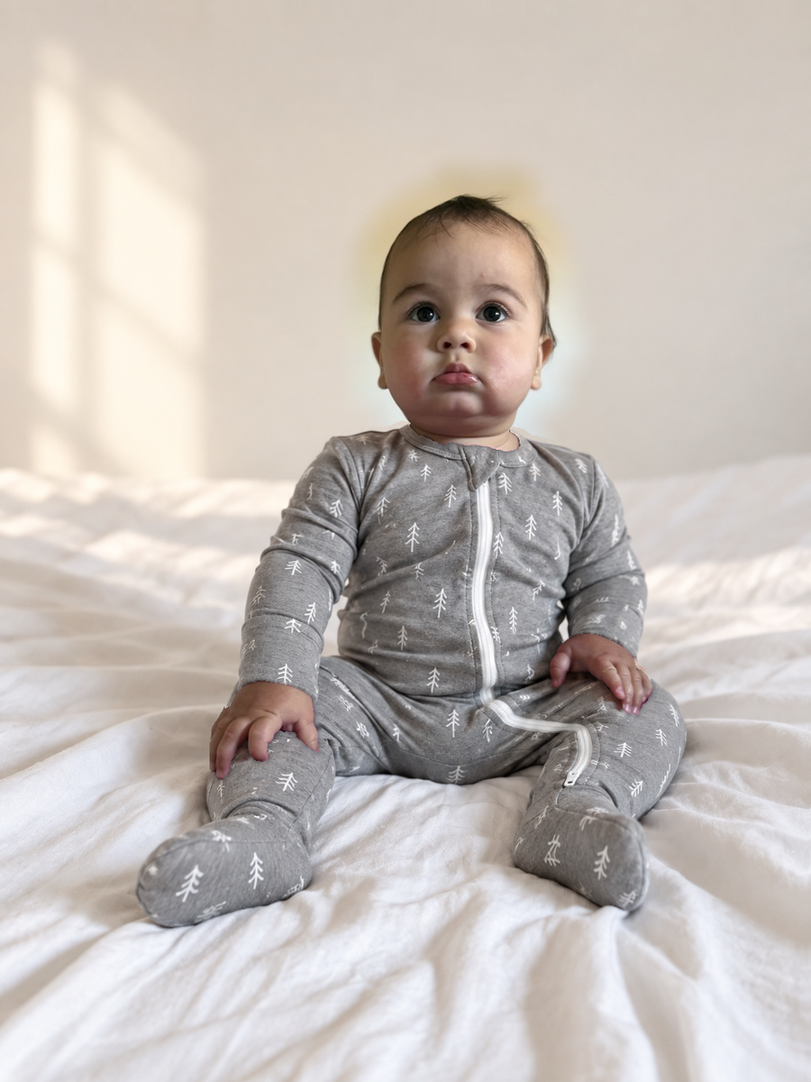 Jordan modeling the Silver Dash Footed Romper by GentleNest Co.