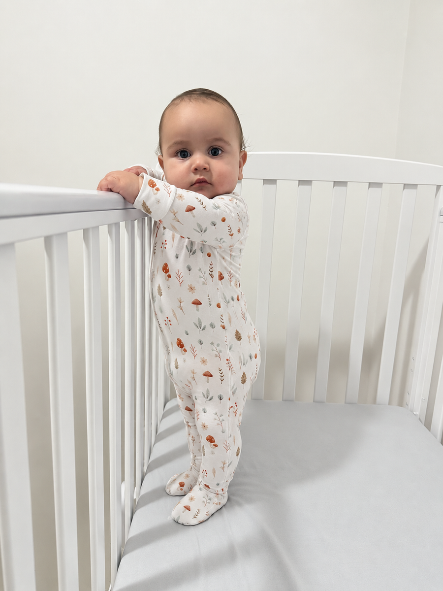 Jordan modeling the Woodland Mushrooms Footed Romper by GentleNest Co.
