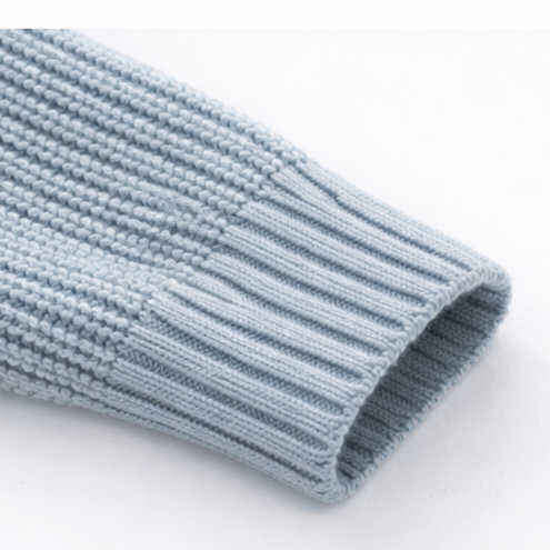 Close-up of a light blue knitted sweater on a white background