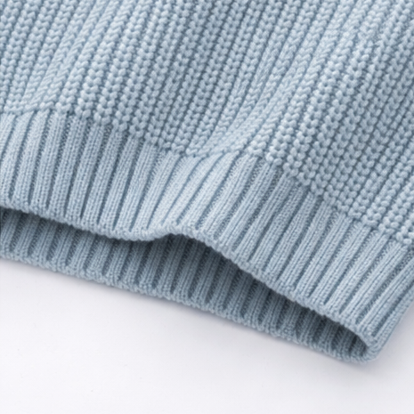 Close-up of a light blue knitted sweater on a white background