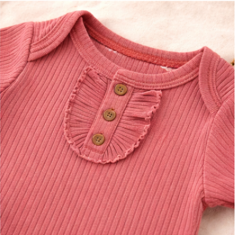 Four baby rompers in pink, orange, peach, and yellow on a light background
