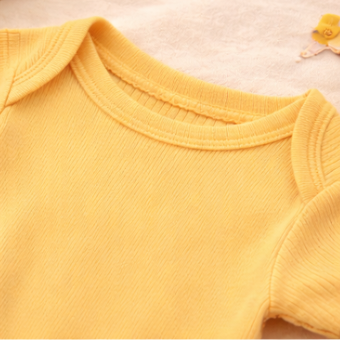 Four baby rompers in pink, orange, peach, and yellow on a light background