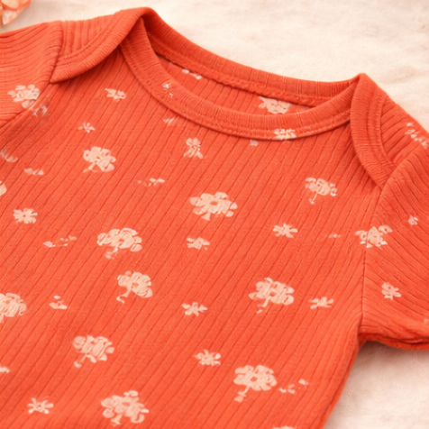 Four baby rompers in pink, orange, peach, and yellow on a light background