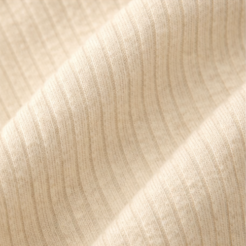 Collage of a beige ribbed baby onesie with buttons on a light background