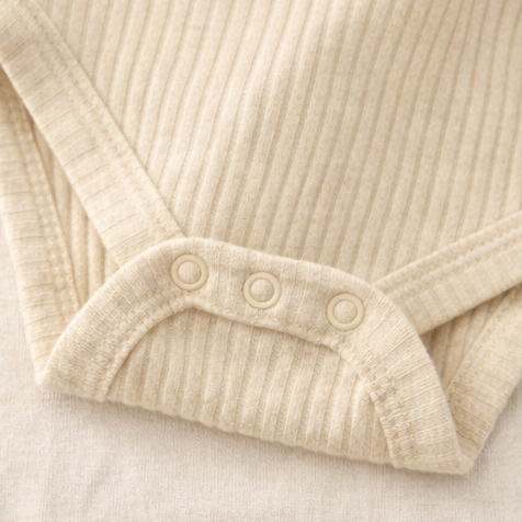 Collage of a beige ribbed baby onesie with buttons on a light background