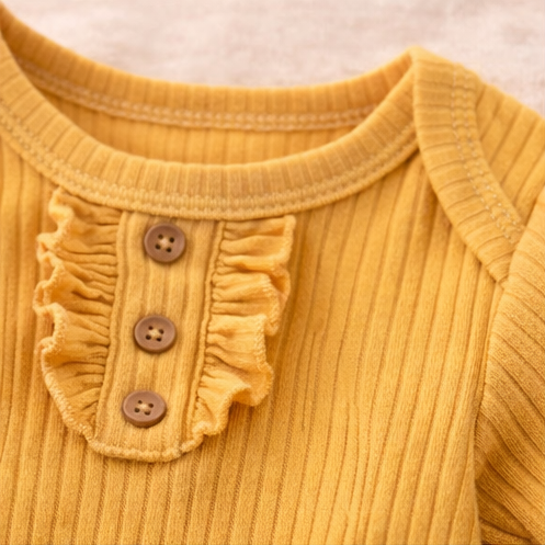Collage of baby clothing items including a yellow onesie with ruffled collar, a white onesie with orange flowers, an orange onesie, and a floral-patterned onesie.