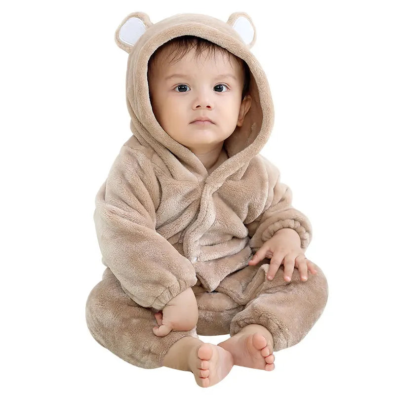 Child wearing brown bear plush hooded romper costume sitting on floor