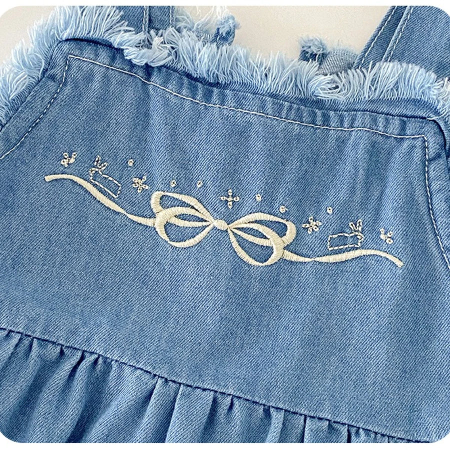 Close-up of bow embroidery on cotton denim overall romper