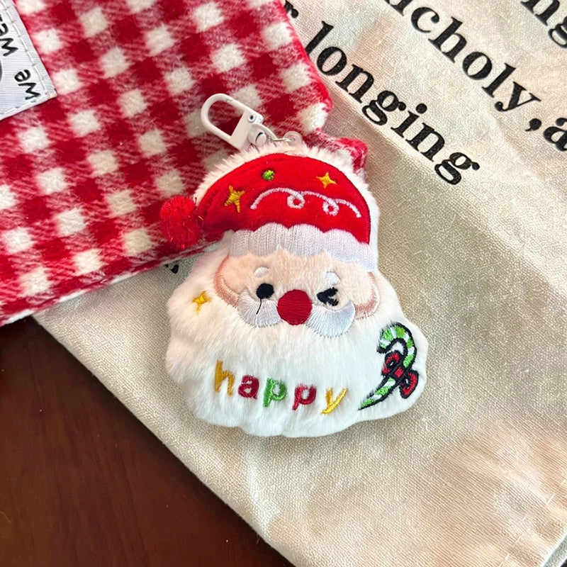 Santa plush Christmas ornament with a red hat, white beard, stitched happy lettering, and a white clip.