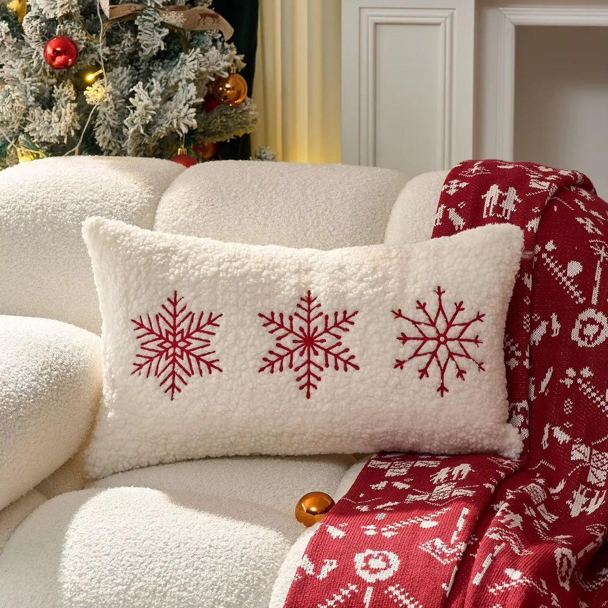 Christmas pillow cover featuring three red snowflakes on an ivory textured background.