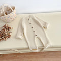 Knitted baby bodysuit in neutral color