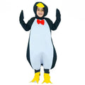 Child wearing a black and white penguin jumpsuit costume with red bow tie, hood with yellow beak, and yellow foot covers.