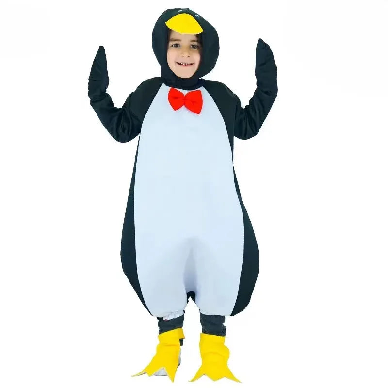 Child wearing a black and white penguin jumpsuit costume with red bow tie, hood with yellow beak, and yellow foot covers.