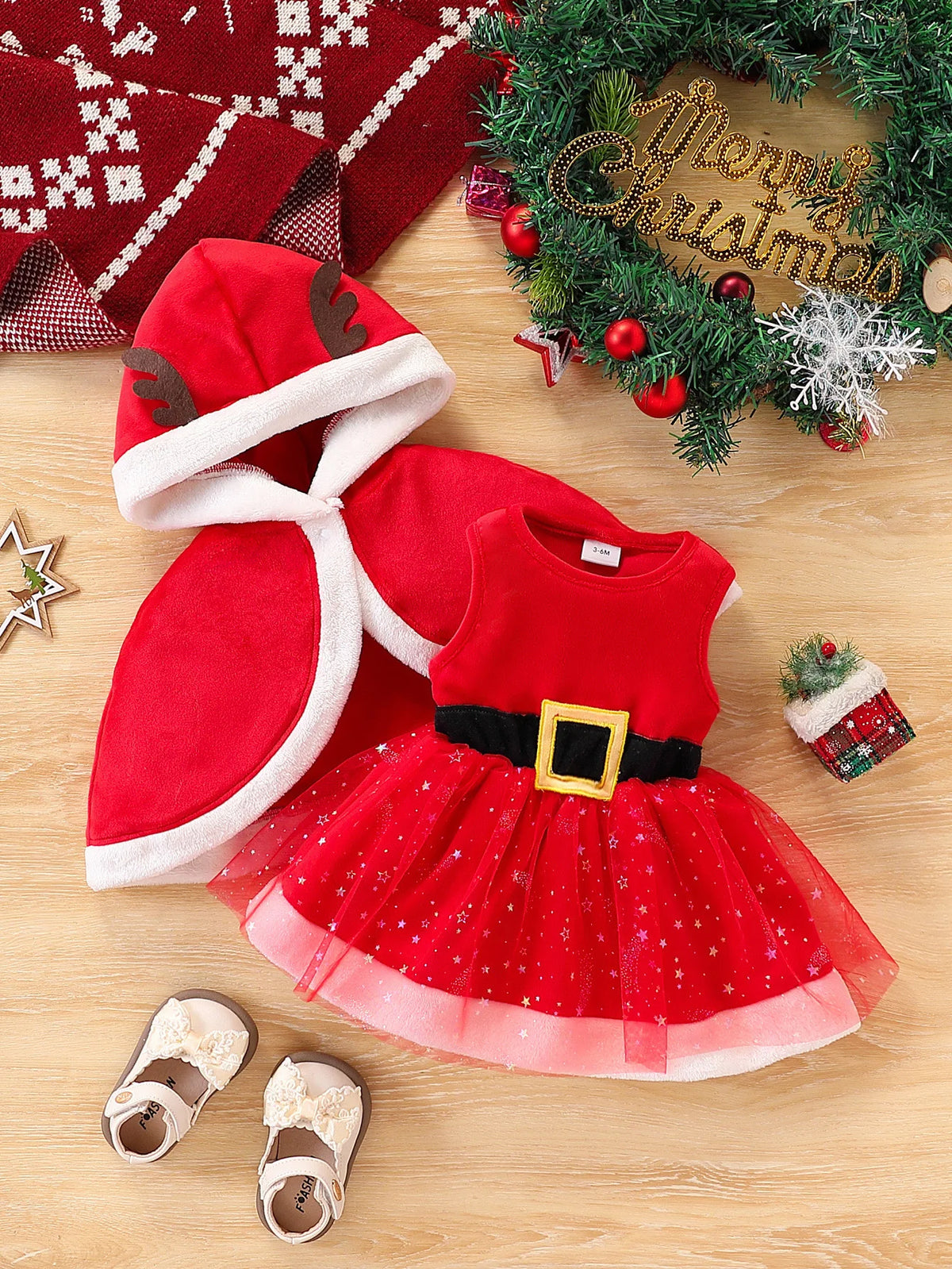 Red Santa-style dress with a star-patterned skirt and black belt detail, shown beside a red antler hooded cape with white trim.