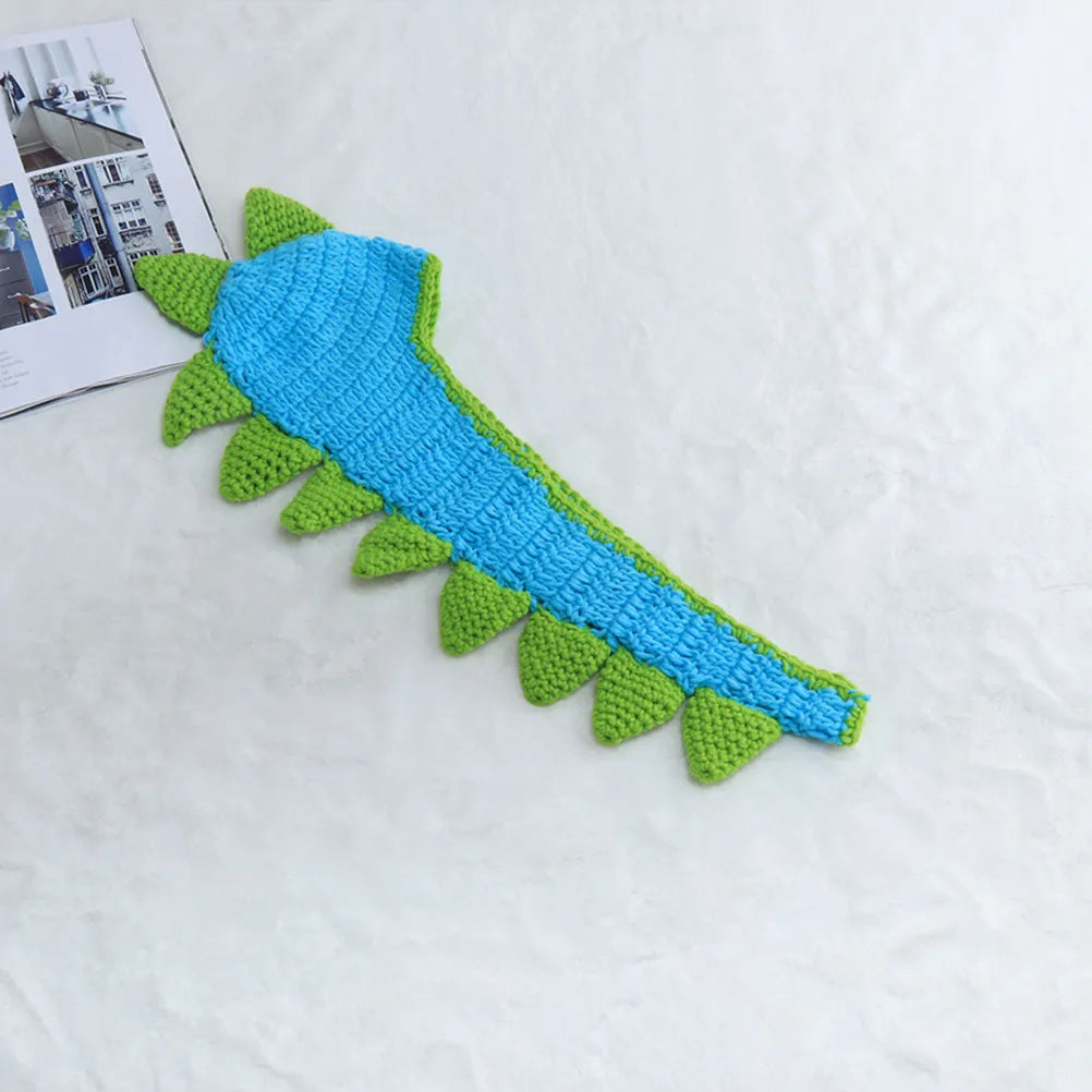 Knitted blue dinosaur tail with green spikes