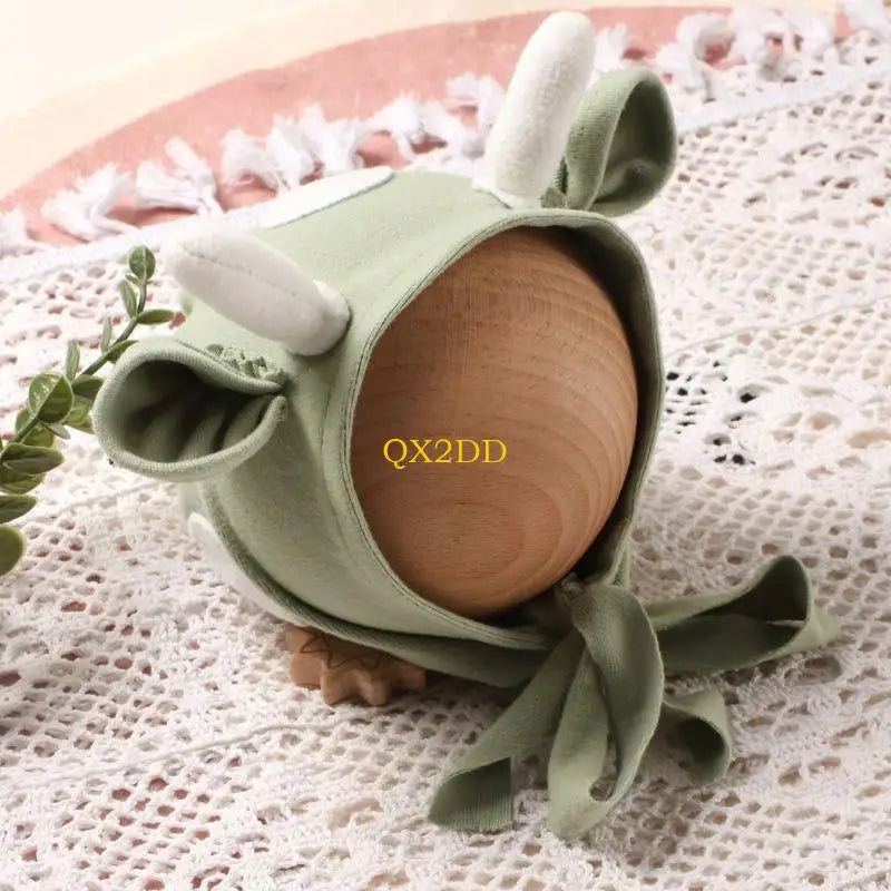 Green cow hat with ears and horns on wooden mannequin head