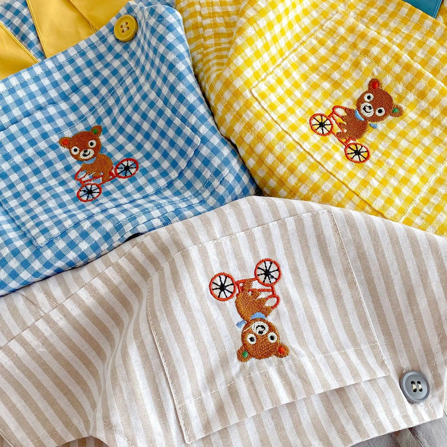 Close view of the bear-on-a-bicycle embroidery and bib pocket