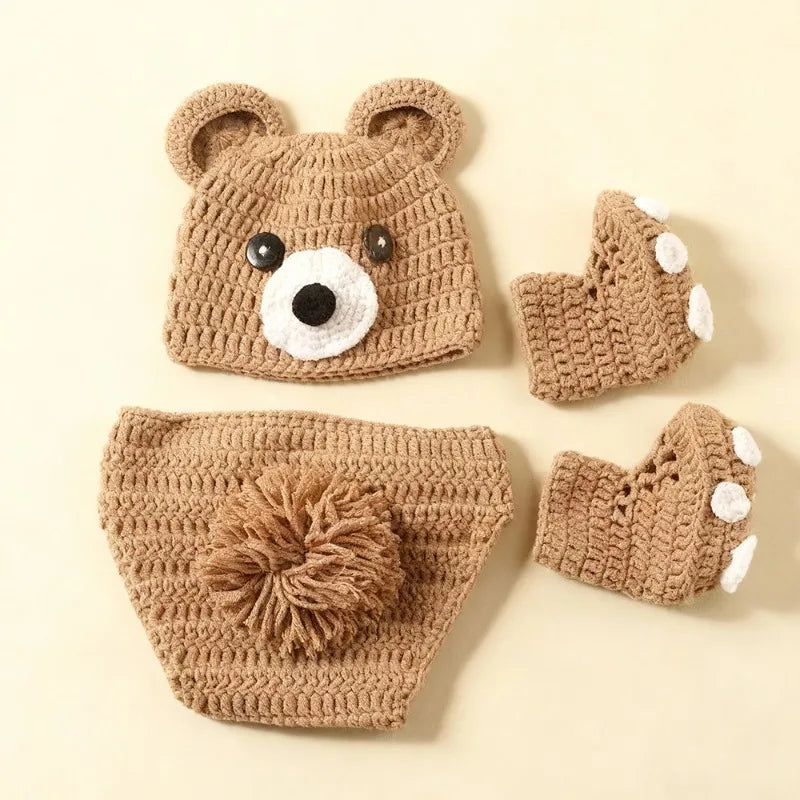 Brown hand-knit newborn bear costume with ear hat, pompom-tail shorts, and paw-print booties