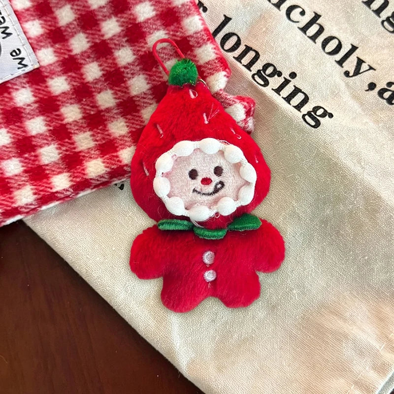 Red hooded Christmas character plush ornament with a green collar, smiling face, and red clip.