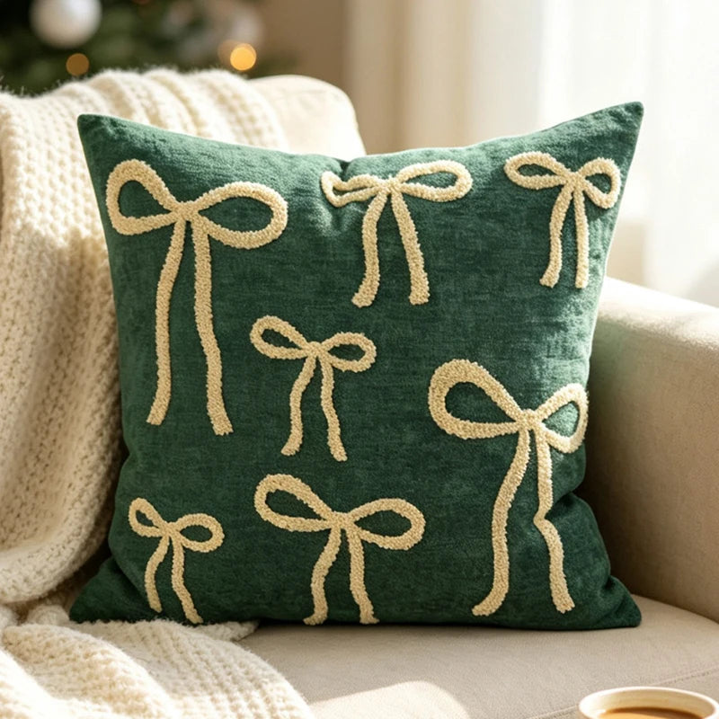 Christmas pillow cover featuring cream-colored bows on a green background.