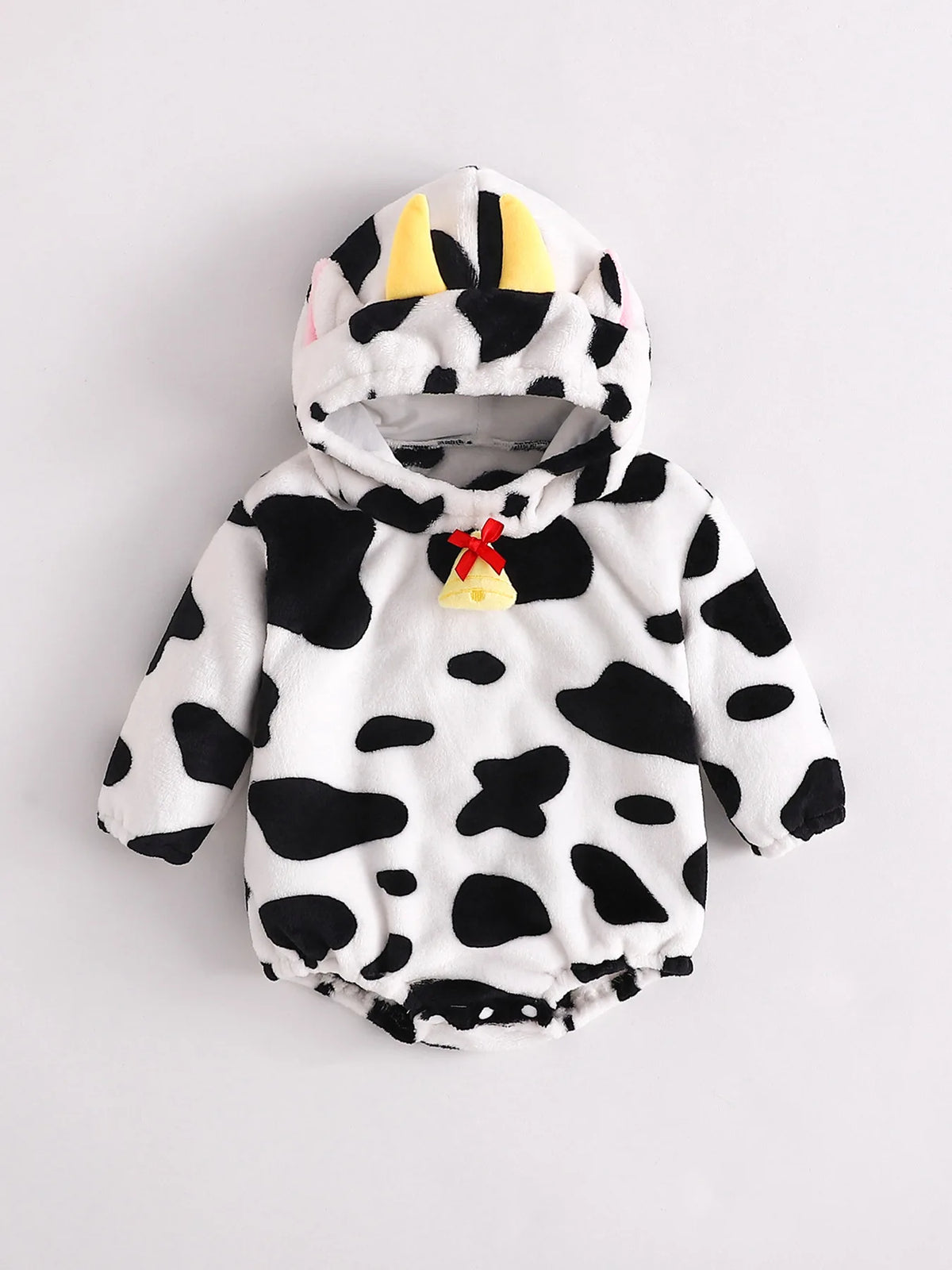 Infant cow print fleece romper costume with hood featuring yellow horns and pink ears, and a decorative bell at neckline.