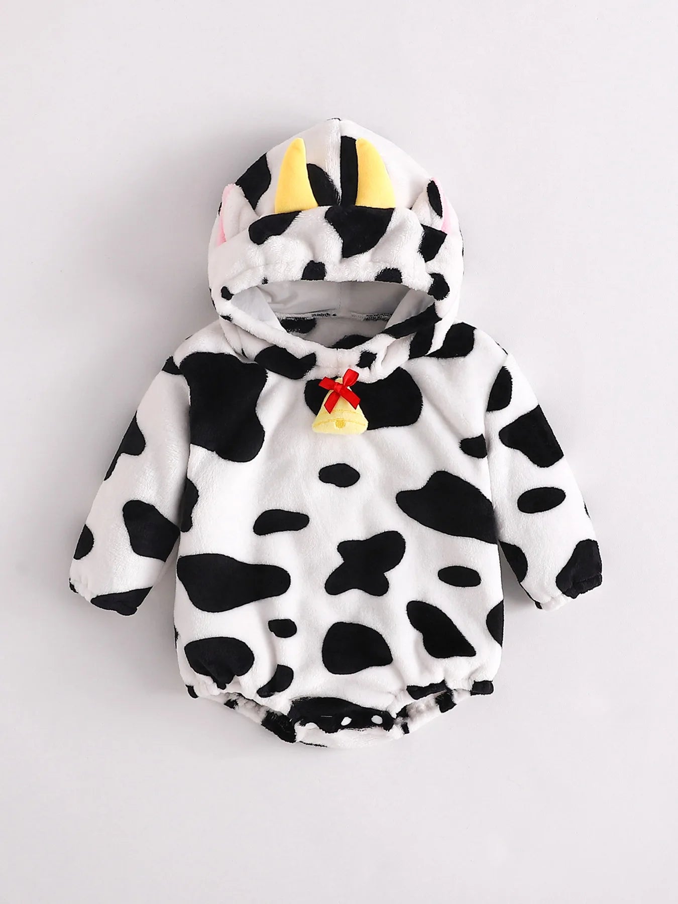 Infant cow print fleece romper costume with hood featuring yellow horns and pink ears, and a decorative bell at neckline.