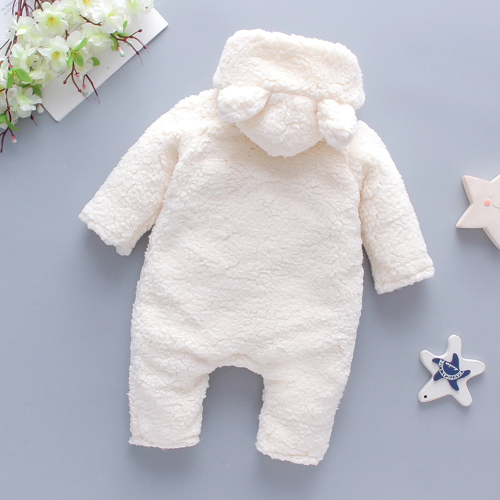 Close-up of embroidered bear detail on lamb hair baby romper