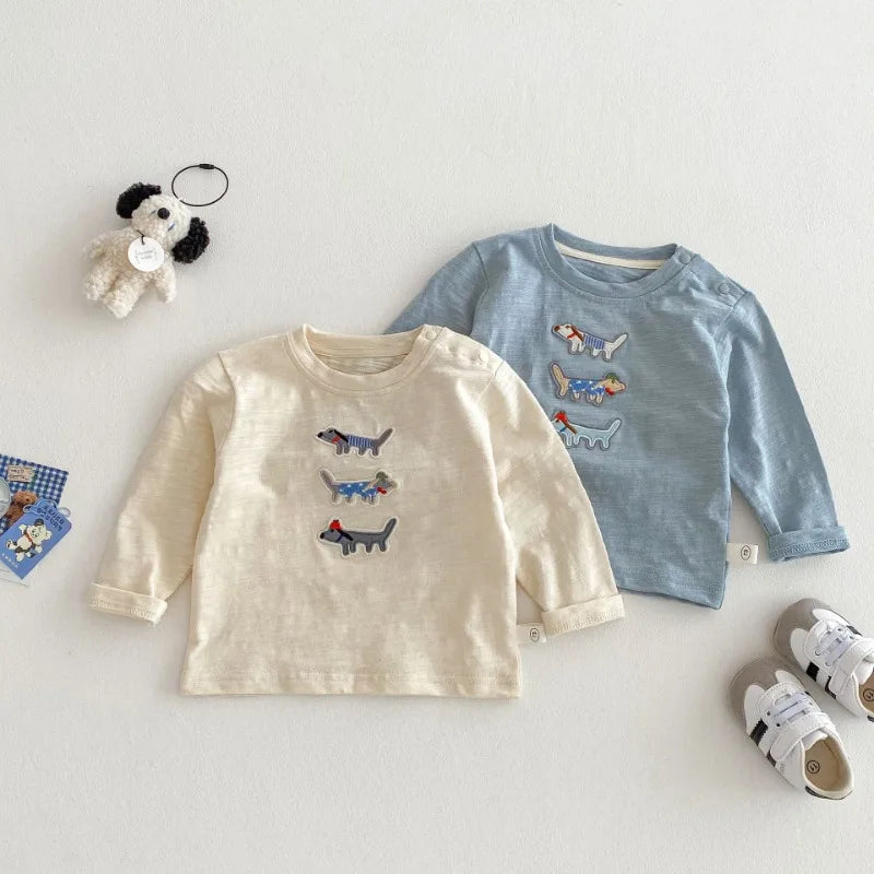 Beige and blue embroidered dog cotton tops laid flat