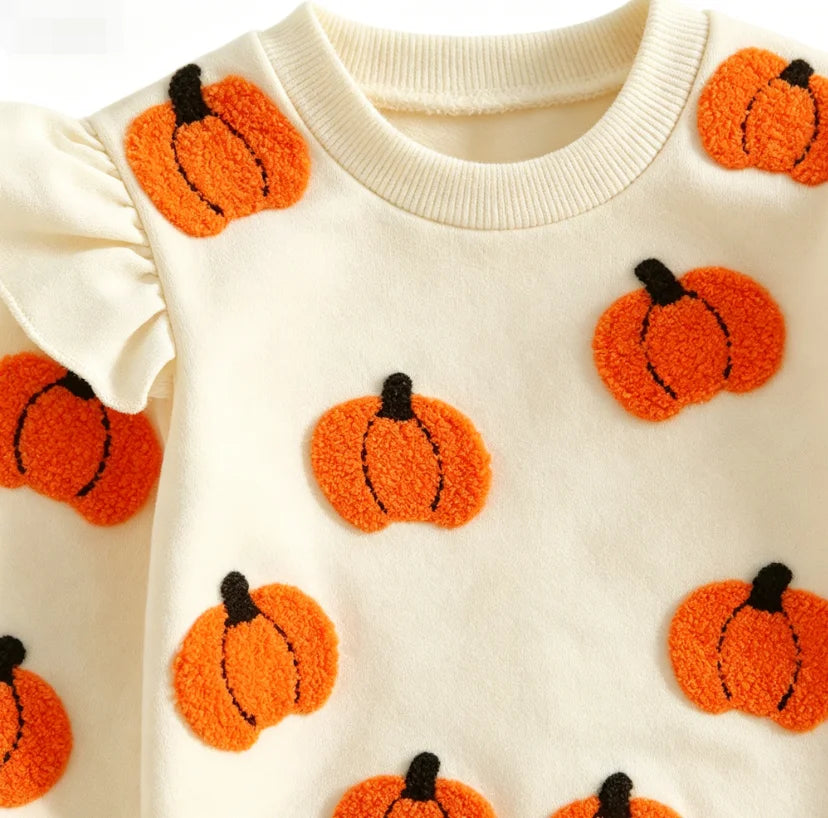 Close-up of beige pumpkin applique on infant bodysuit with ruffle sleeve detail