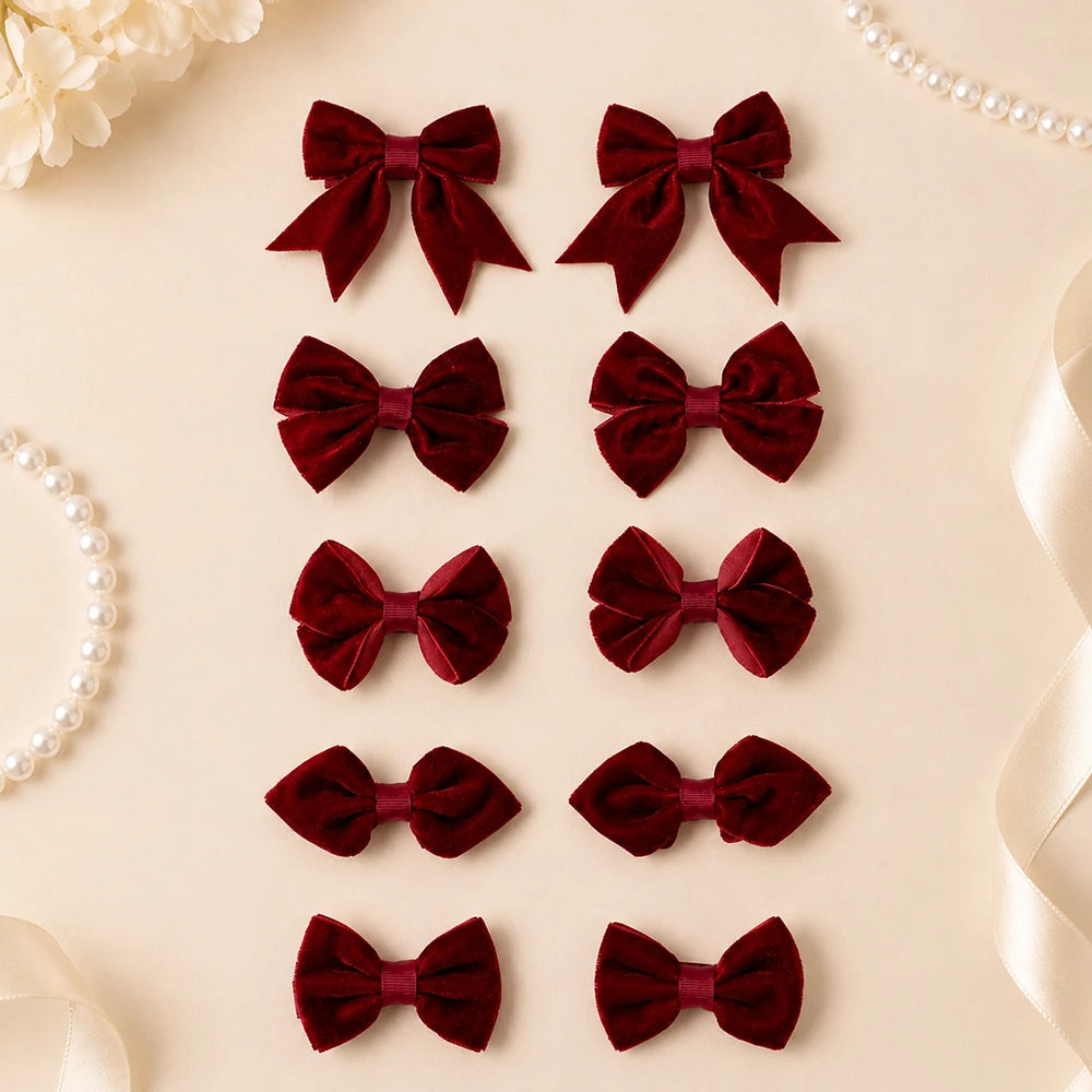Ten burgundy bow hair clips in five paired styles, arranged on a cream background.