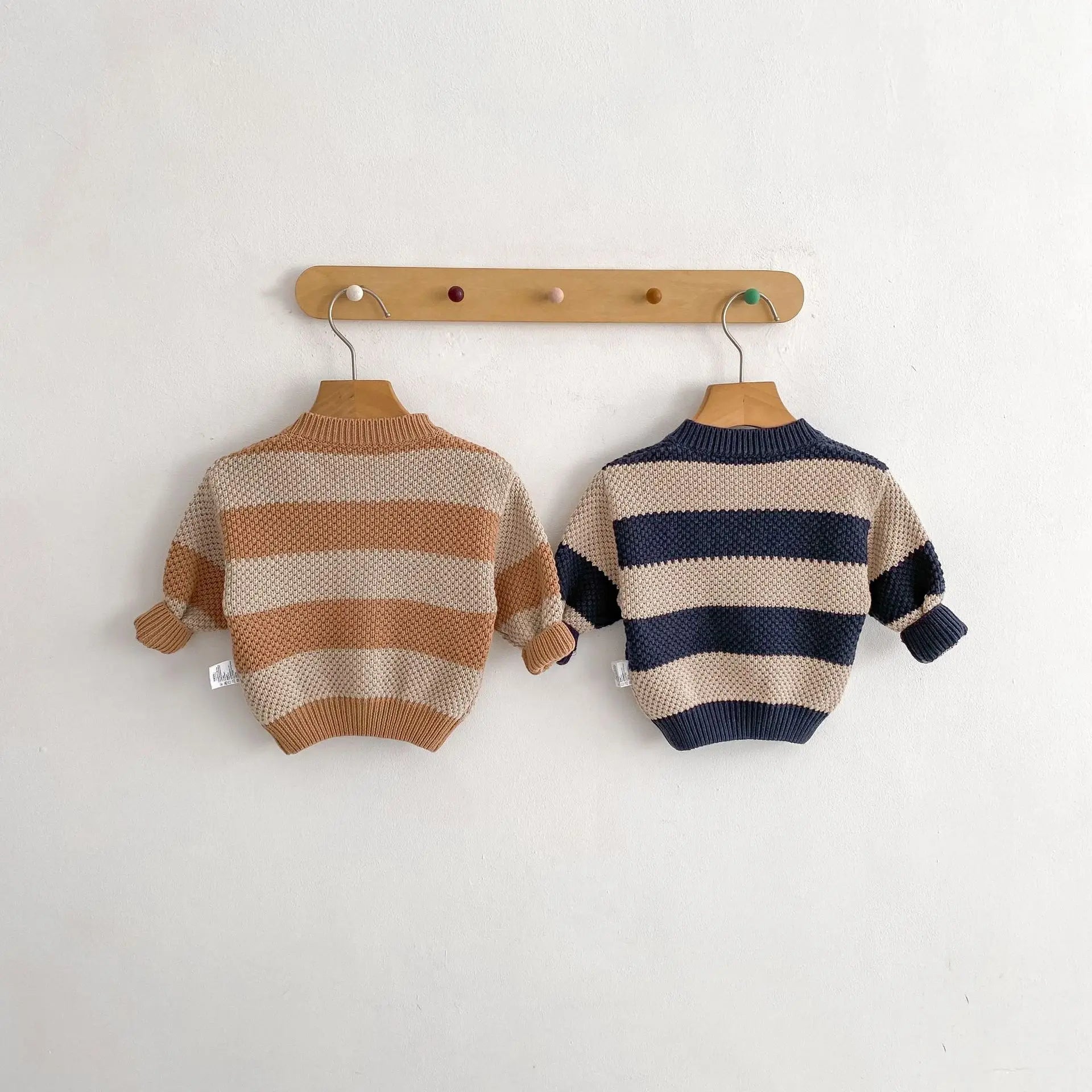 Close-up of striped knitted cardigan sweater jacket for babies in black