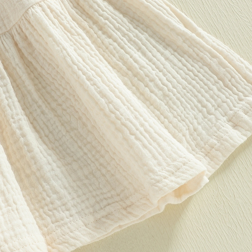 Cotton-rich textured skirt detail on ivory dress