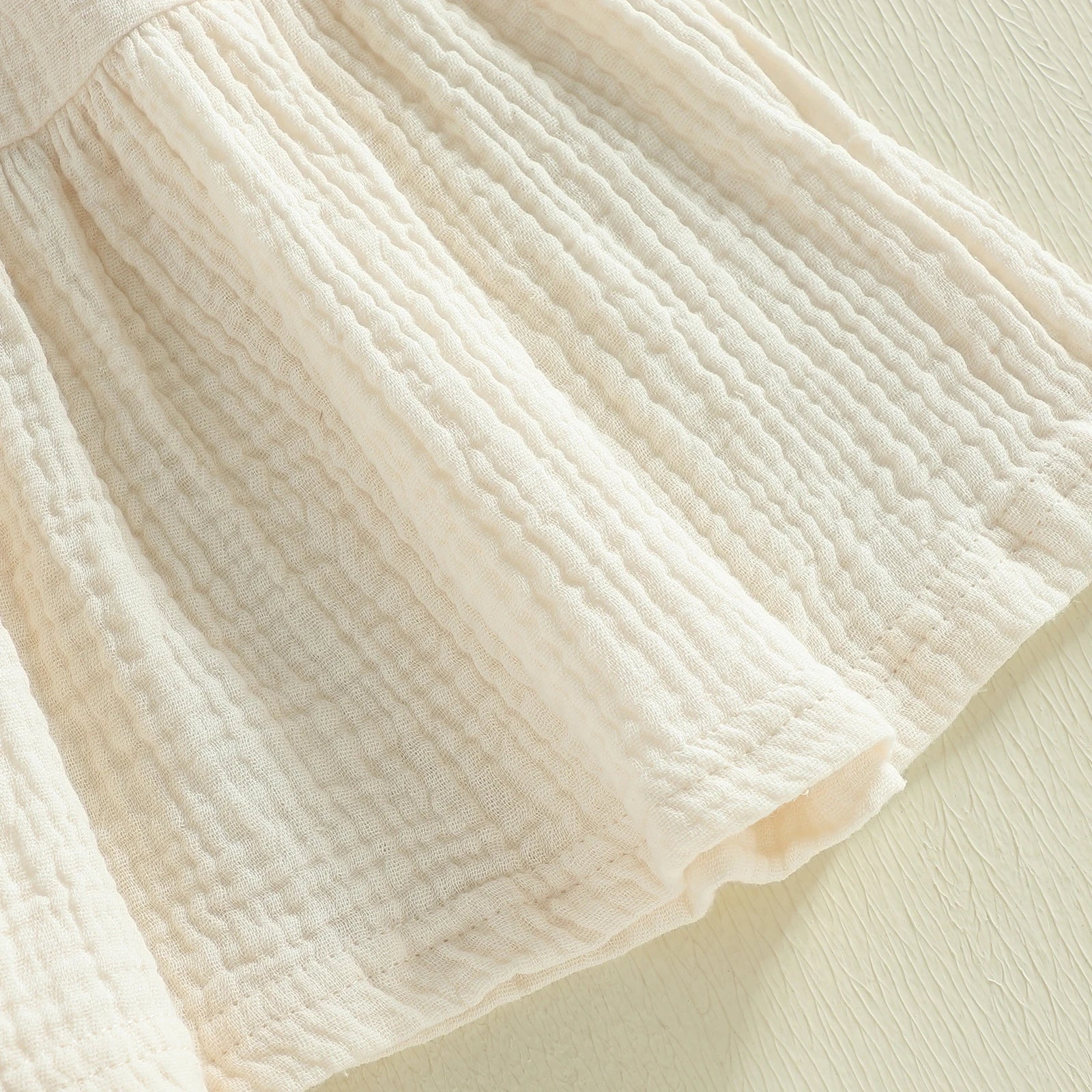 Cotton-rich textured skirt detail on ivory dress