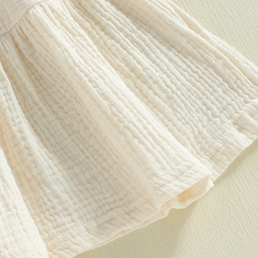 Cotton-rich textured skirt detail on ivory dress