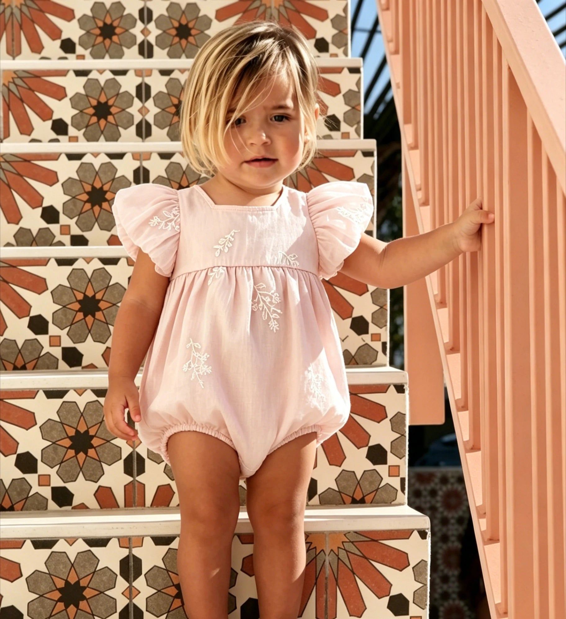 Pink embroidered short sleeve baby romper with floral design
