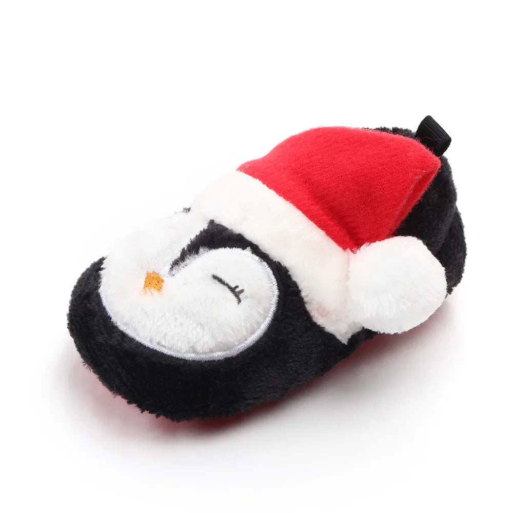 Black-and-white penguin baby shoe with an orange beak and red Santa hat.