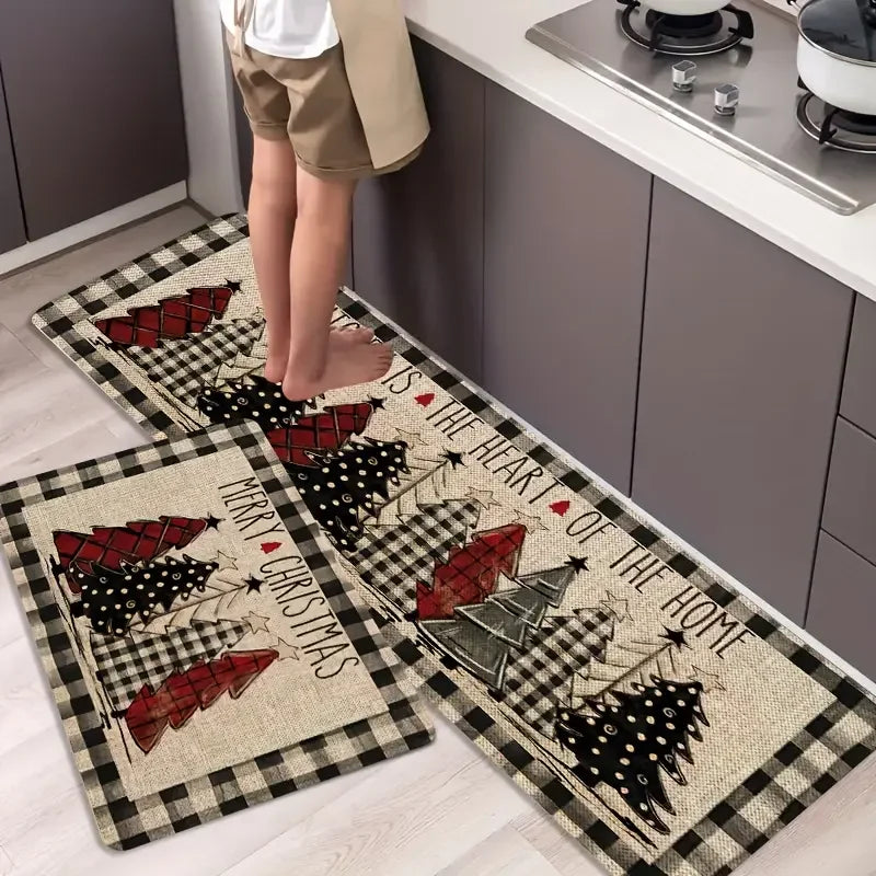 Rectangular Christmas floor mats with plaid tree designs and black-and-cream checked borders, shown in a kitchen.