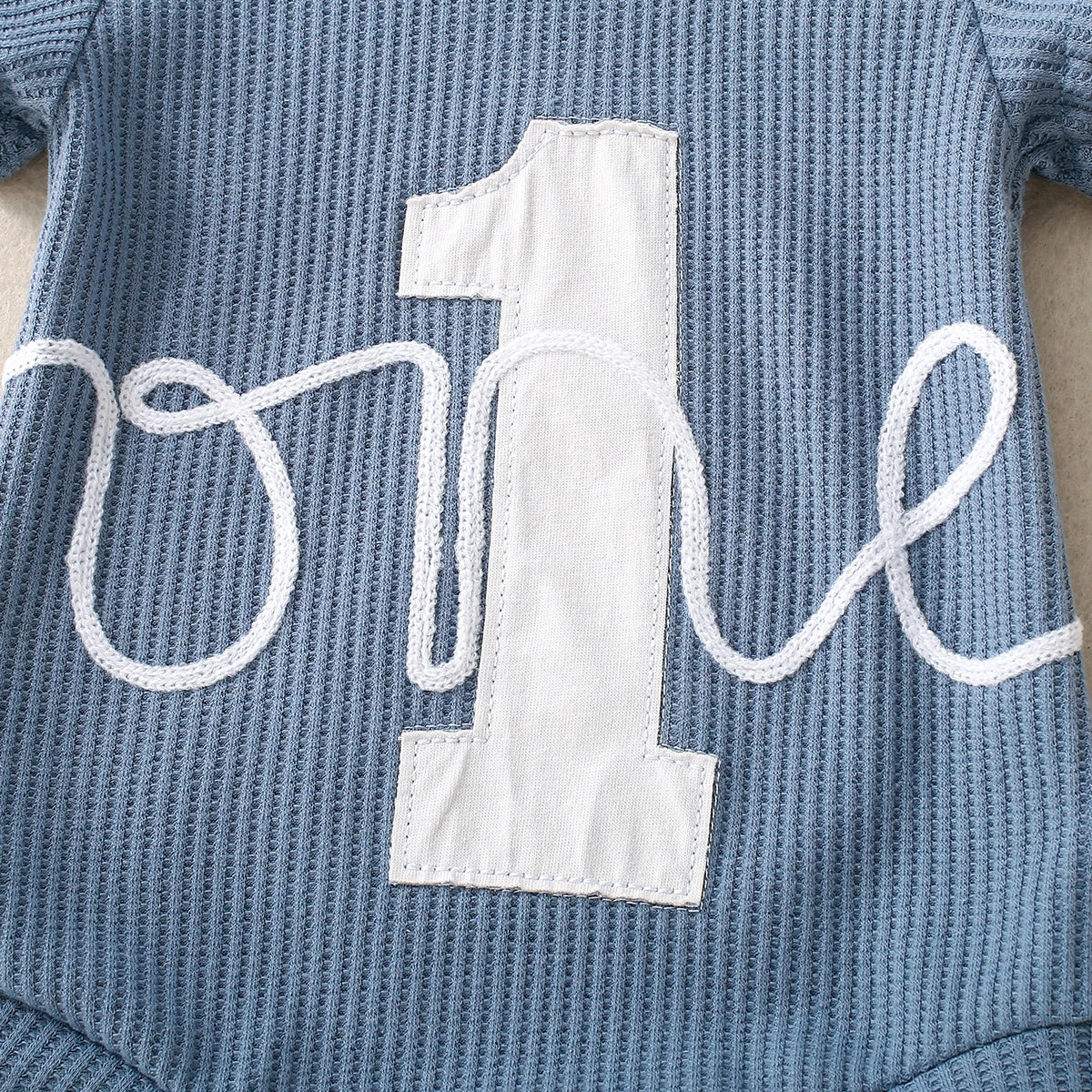Close-up of embroidered triangle detail on romper