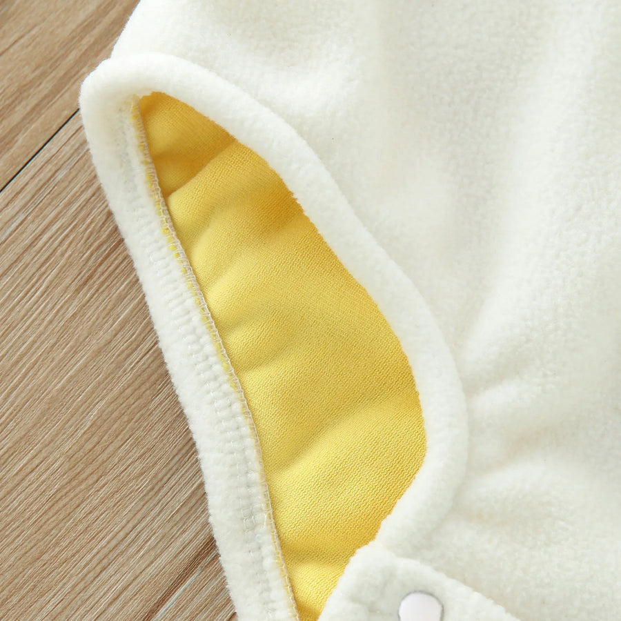 Close-up of white eggshell fabric detail on yellow chick costume romper