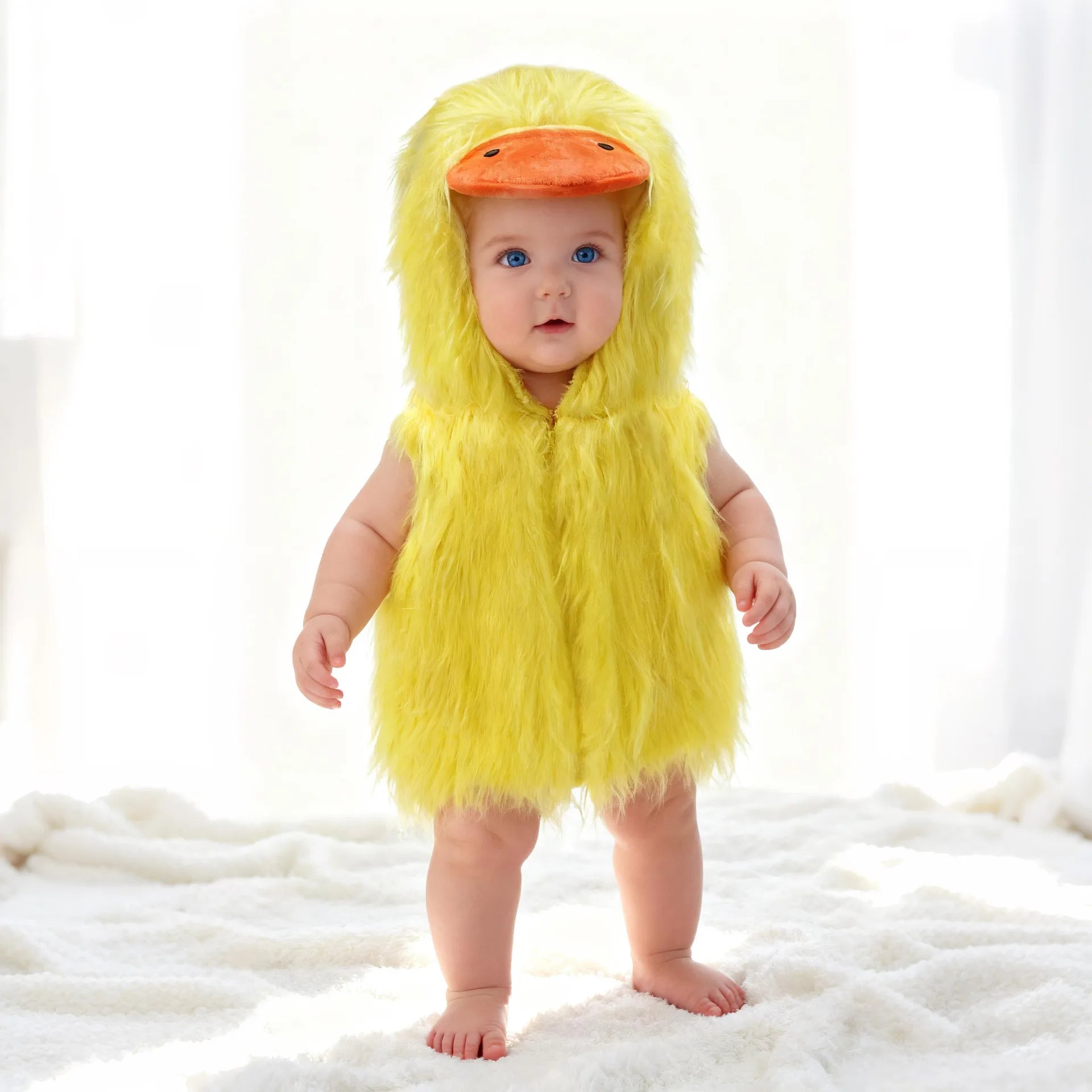 Baby wearing a yellow duck romper costume with hood featuring an orange duck bill