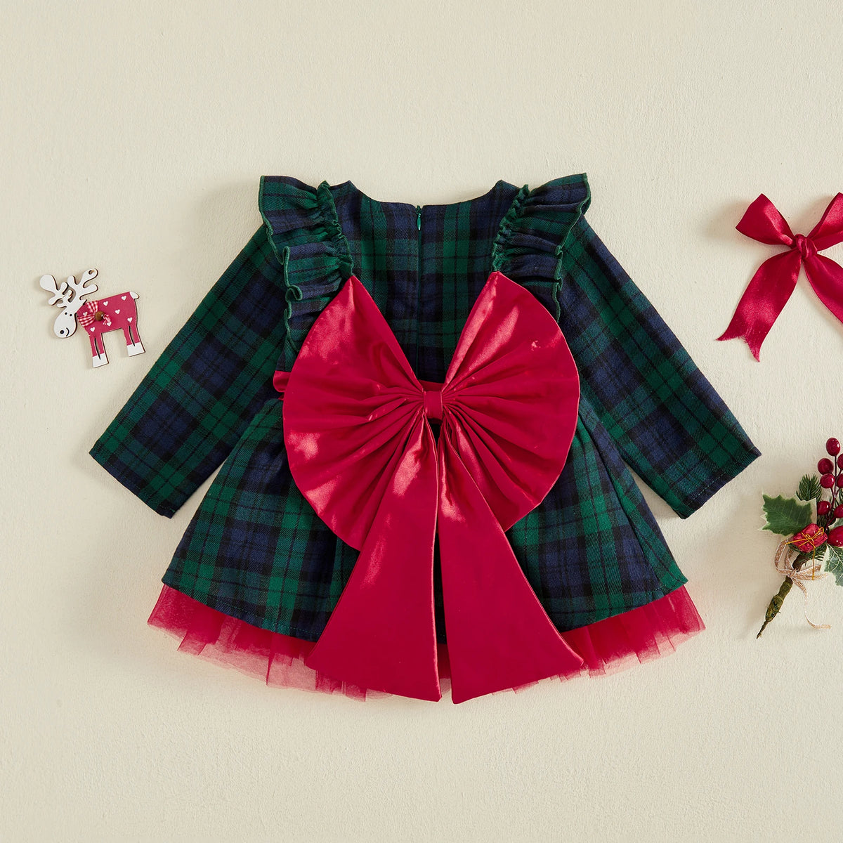 Green and navy plaid long-sleeve dress with ruffled shoulders, a large red bow, and red tulle showing at the hem.