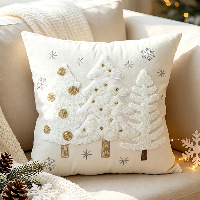 Christmas pillow cover featuring three white Christmas trees with gold-colored accents and snowflakes.