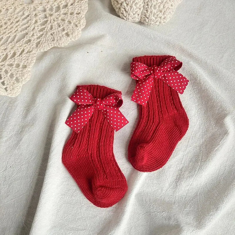 Red ribbed knee-high socks with small white polka-dot bows